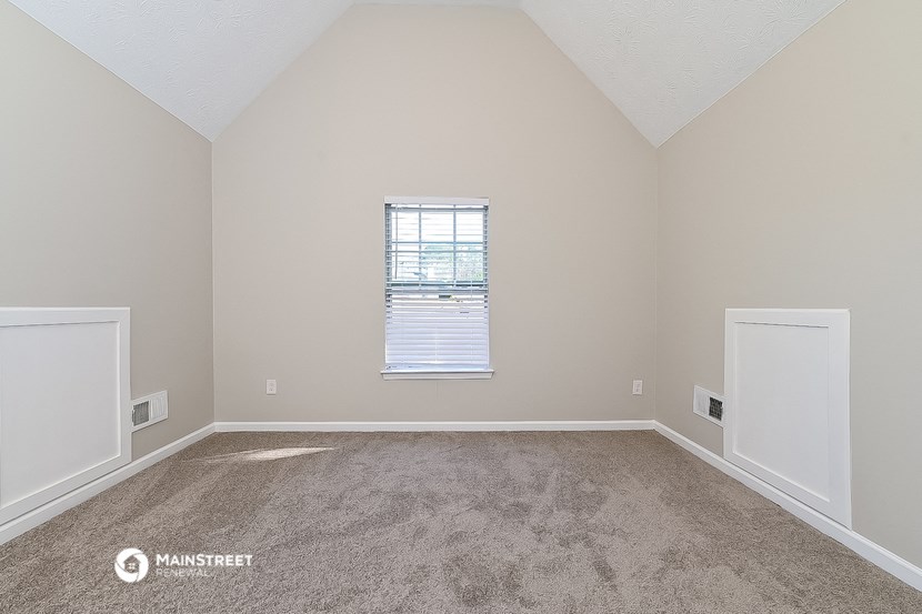 an empty room with carpet and a window