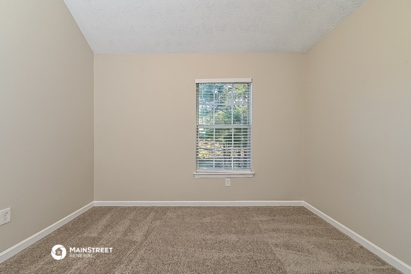 an empty room with carpet and a window