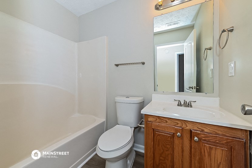 a bathroom with a sink toilet and a mirror
