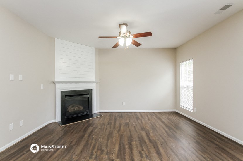 the living room with fireplace and ceiling fan