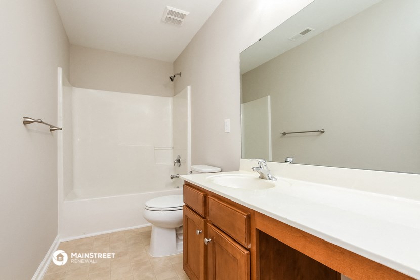 a bathroom with a large mirror and a sink and a toilet