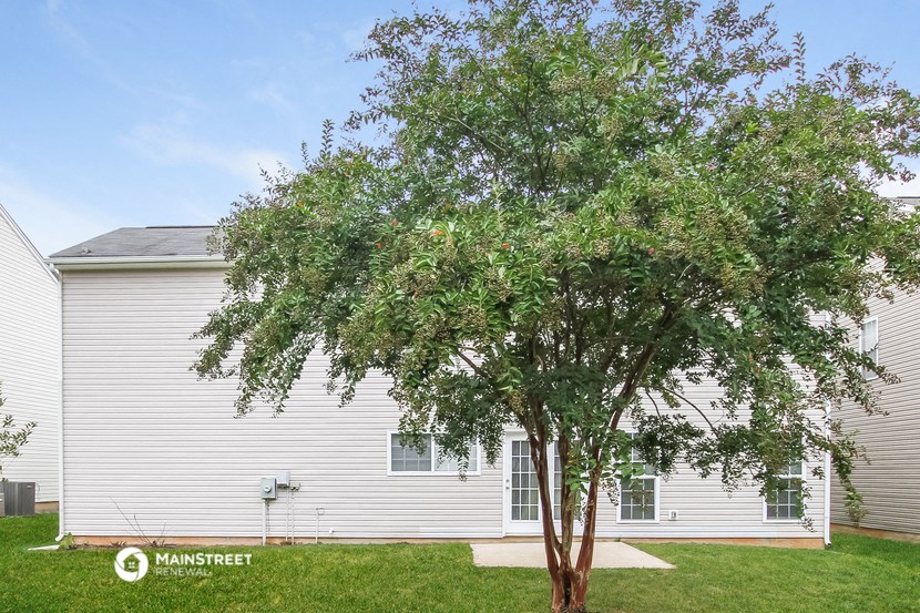 a white house with a tree in front of it