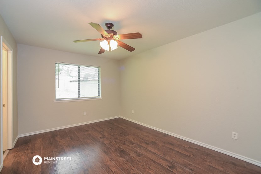 the bedroom with hardwood flooring and a ceiling fan