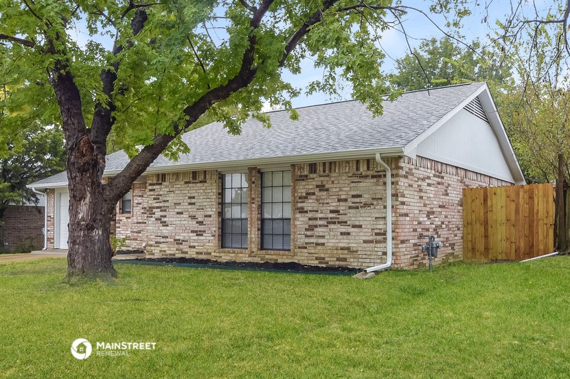 a brick house with a tree in the yard