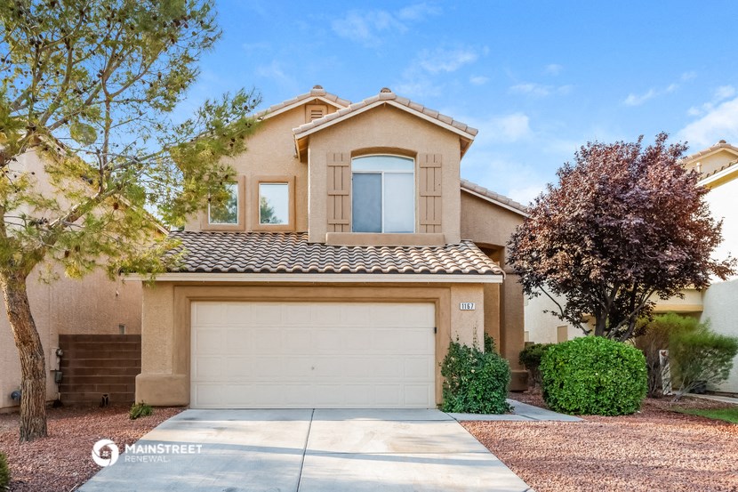 a beige house with a garage and a tree