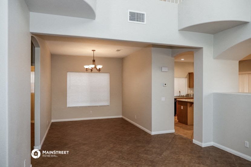 the spacious living room with the kitchen in the background