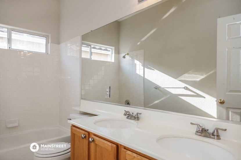 a bathroom with two sinks and a tub and a mirror