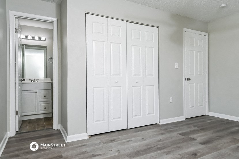the master bedroom of a new home with white doors and a bathroom