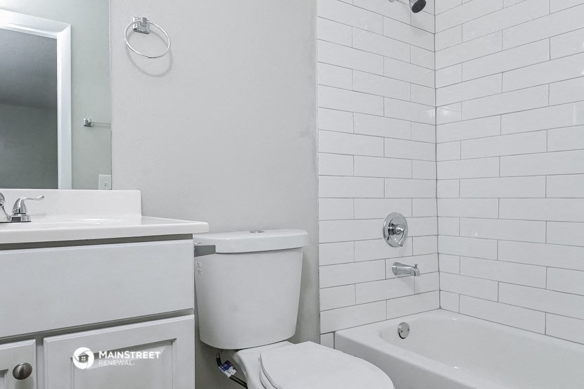 a bathroom with a toilet and a tub and a sink