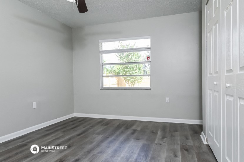 the living room of an apartment with wood floors and a window