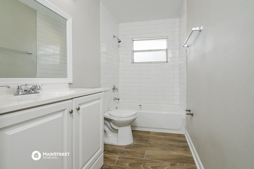 a white bathroom with a toilet and a tub and a sink