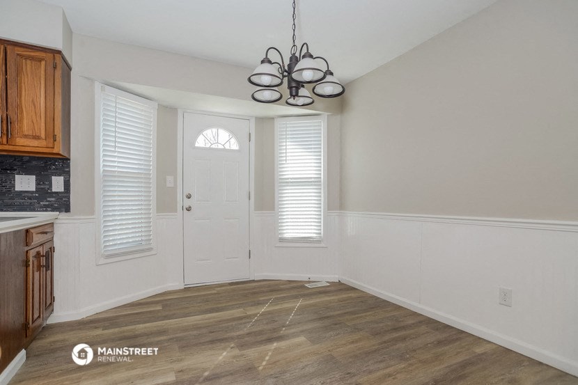 an empty kitchen with white walls and a white door