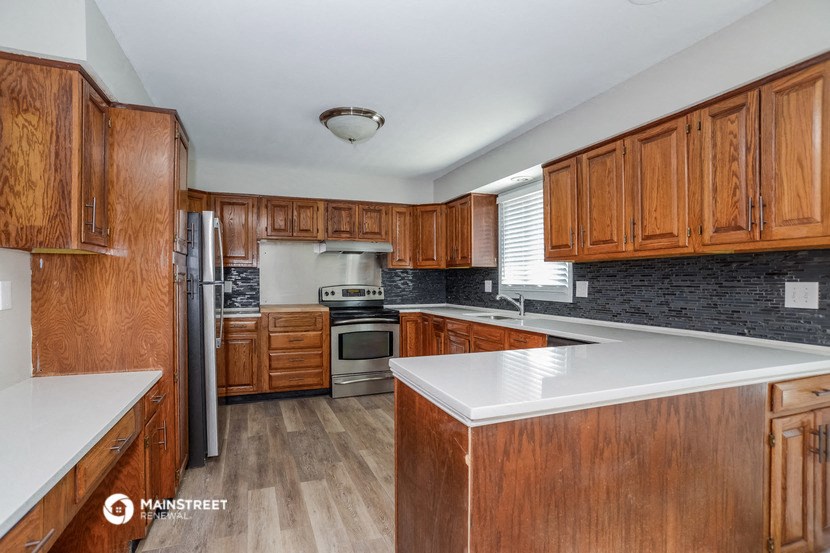 a kitchen with wooden cabinets and a white counter top