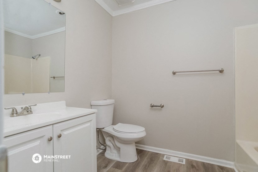 a white bathroom with a toilet and a sink