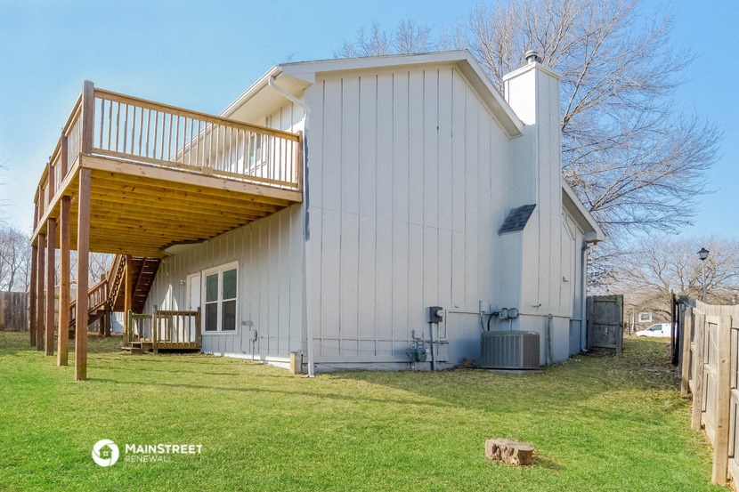 a white barn with a deck on the side of it