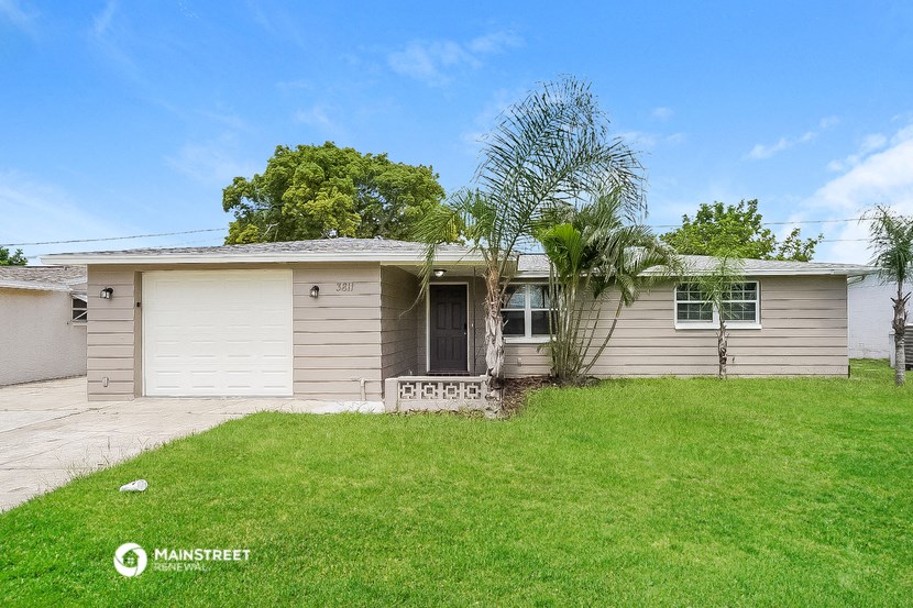 a small tan and with a grassy yard