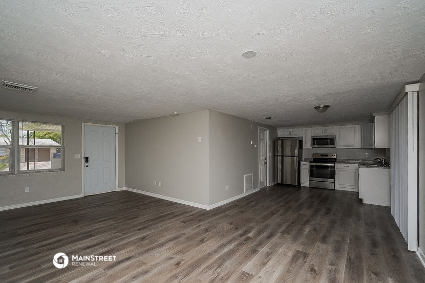 the living room and kitchen of an empty house