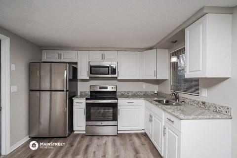 a kitchen with white cabinets and stainless steel appliances