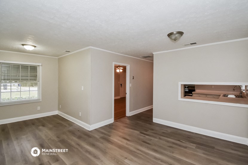 the living room and dining room of an empty house