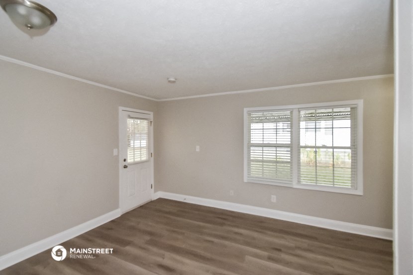 the interior of an empty room with wooden floors and white walls