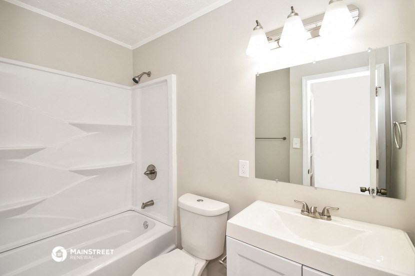 a bathroom with a sink toilet and bath tub and a mirror