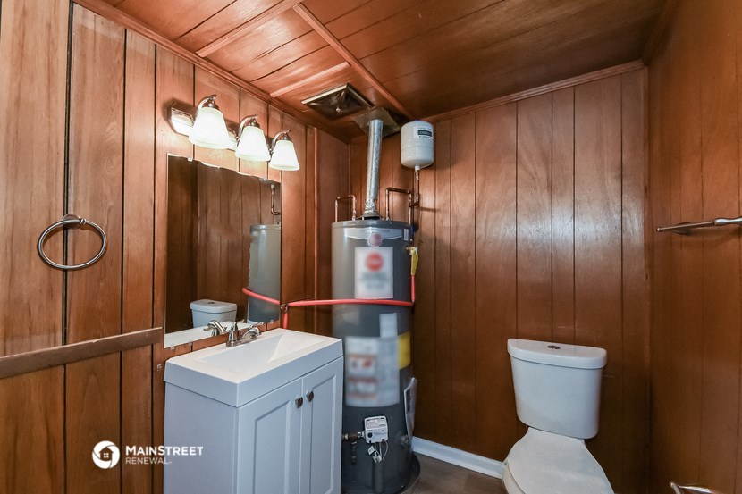 a bathroom with a toilet and a sink and a water tank