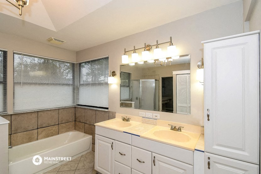 a bathroom with a sink and a tub and a mirror