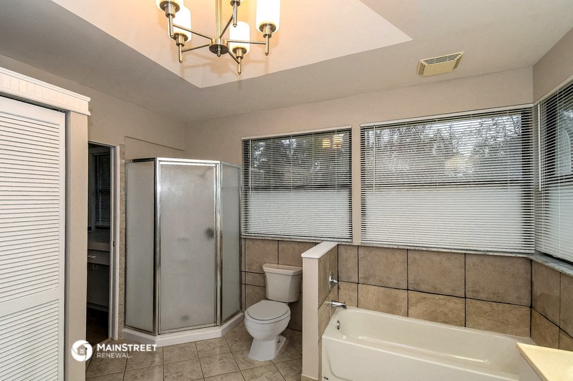 a bathroom with a tub and a shower and a toilet