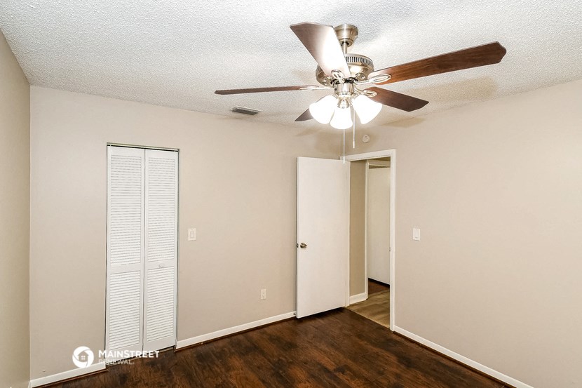a bedroom with a ceiling fan and a closet