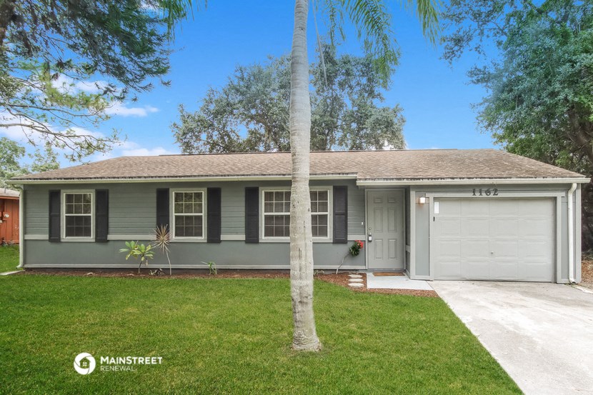a green house with a palm tree in front of it