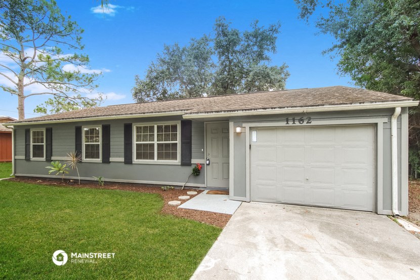 a home with a white garage door and a lawn