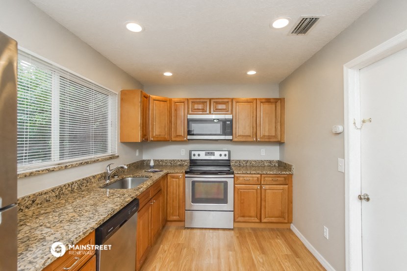 a kitchen with wooden cabinets and granite counter tops and stainless steel appliances