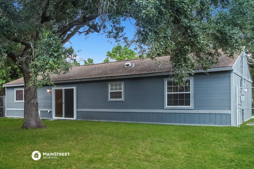 a blue house with a tree in the yard