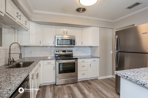 a kitchen with white cabinets and stainless steel appliances