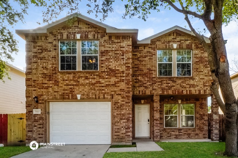 the front of a brick house with a white garage door
