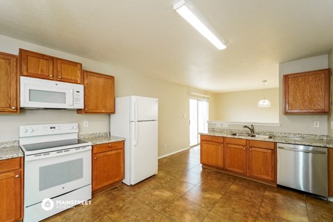 a kitchen with white appliances and wooden cabinets