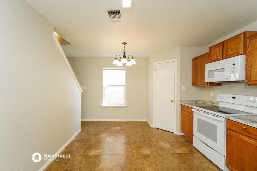 a kitchen with white appliances and wooden cabinets