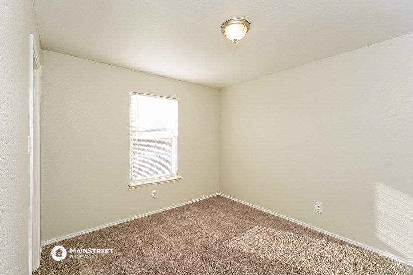 the spacious living room with carpeting and a window