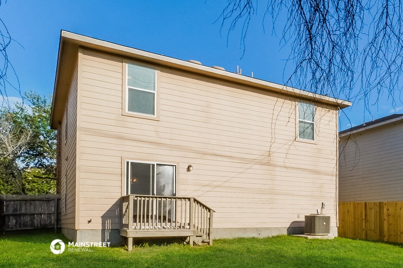 a small house with a porch and a wooden fence