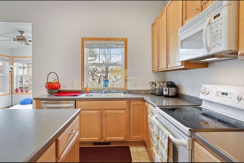 a kitchen with a stove and a sink and a window