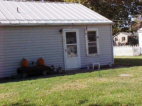 A small house with a white door and two windows.