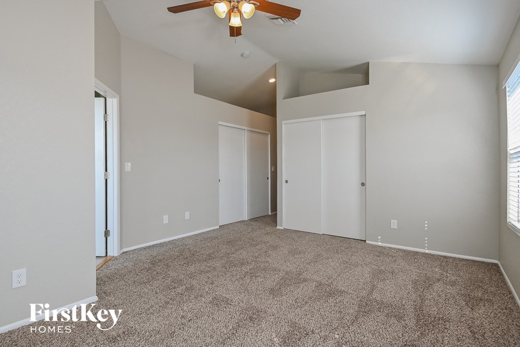 the living room of an empty house with a ceiling fan