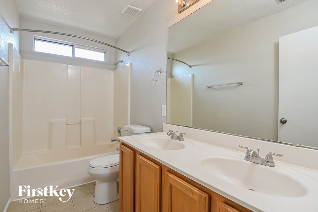 a bathroom with two sinks and a shower and a toilet