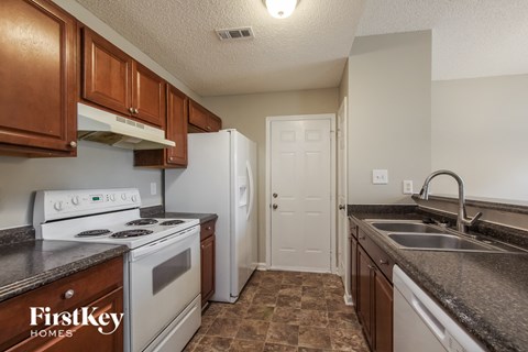 A kitchen with brown cabinets and a white stove top oven.