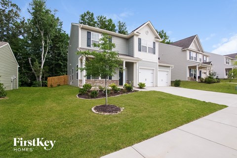 a home with a lawn and a tree in front of it