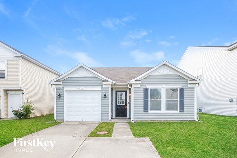 A house with a garage door and a window is for sale.