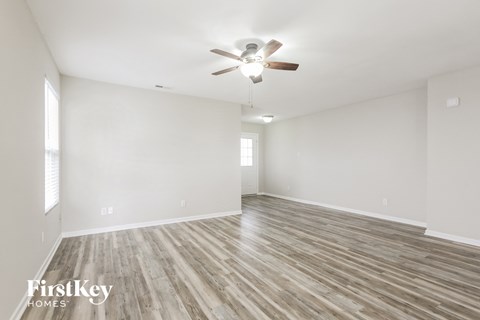 A room with wooden flooring and a ceiling fan.