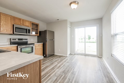 A kitchen with wooden cabinets and a stainless steel refrigerator.