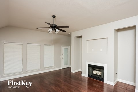 a living room with a ceiling fan and a fireplace
