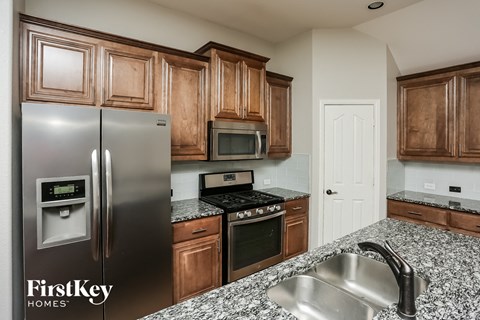an updated kitchen with stainless steel appliances and granite counter tops